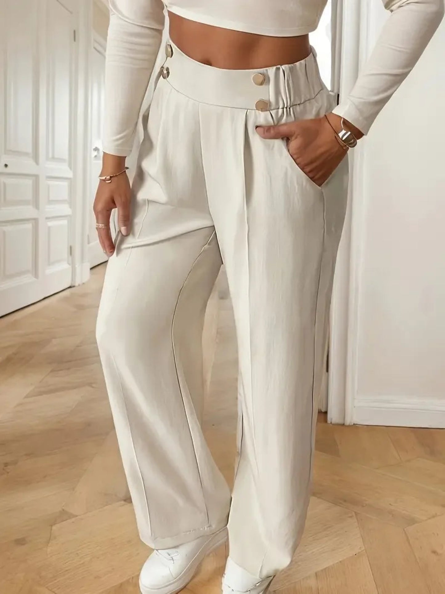 Person wearing a white outfit with wide-leg pants indoors.