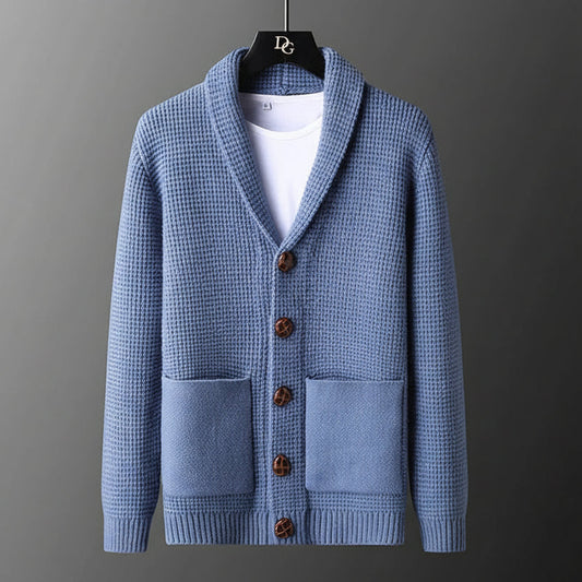 Blue knitted cardigan with brown buttons on a gray background