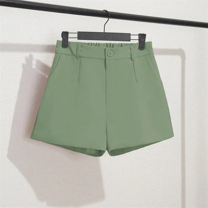 Green shorts on a hanger against a white background