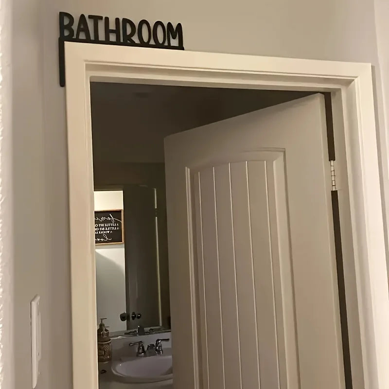 Bathroom door with a 'Bathroom' sign above it, leading to a bathroom interior.