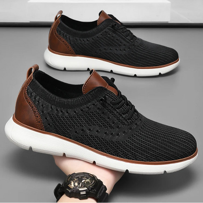 Black and brown sneakers with a white sole on a gray background