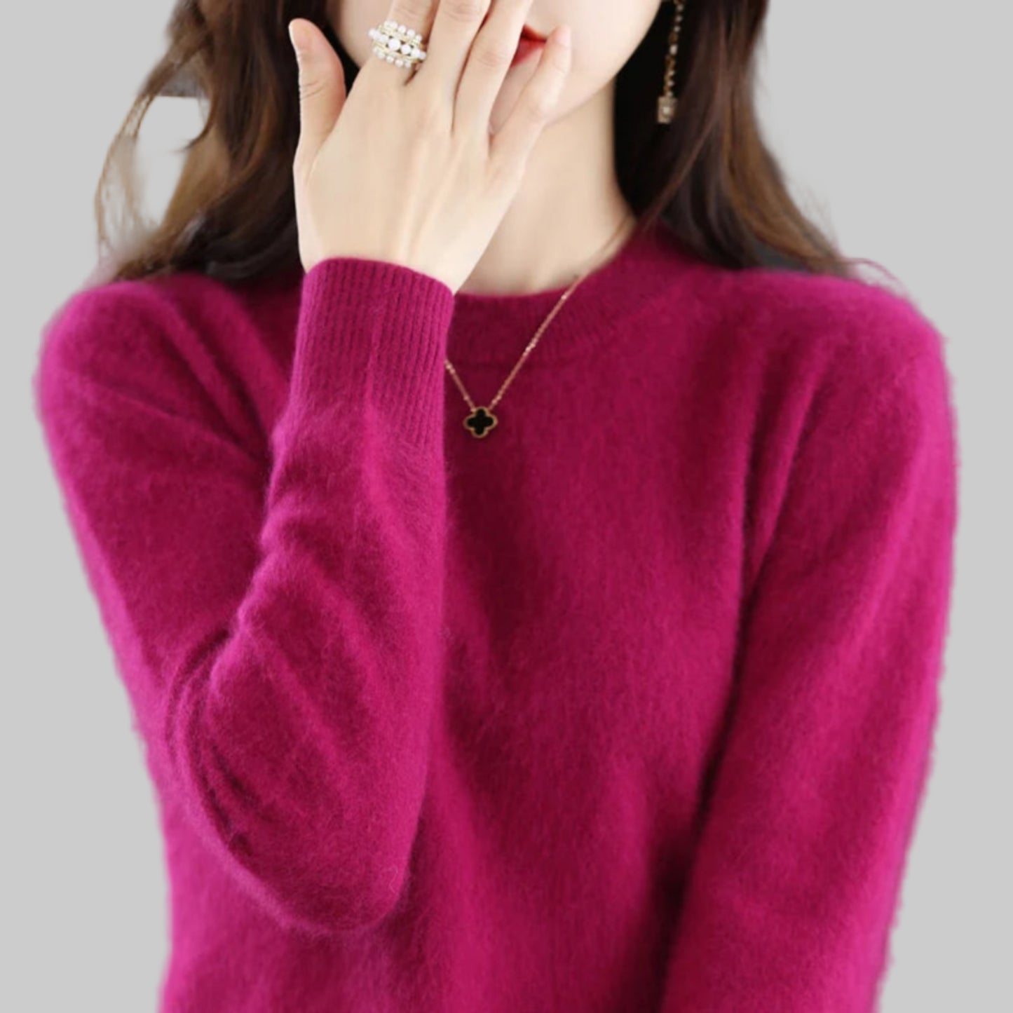 Person wearing a magenta sweater with a blurred background