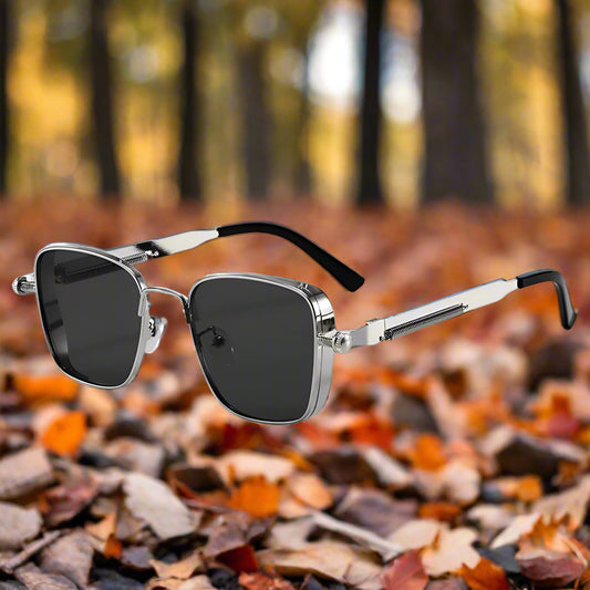 Sunglasses with silver frame and black lenses on a white background