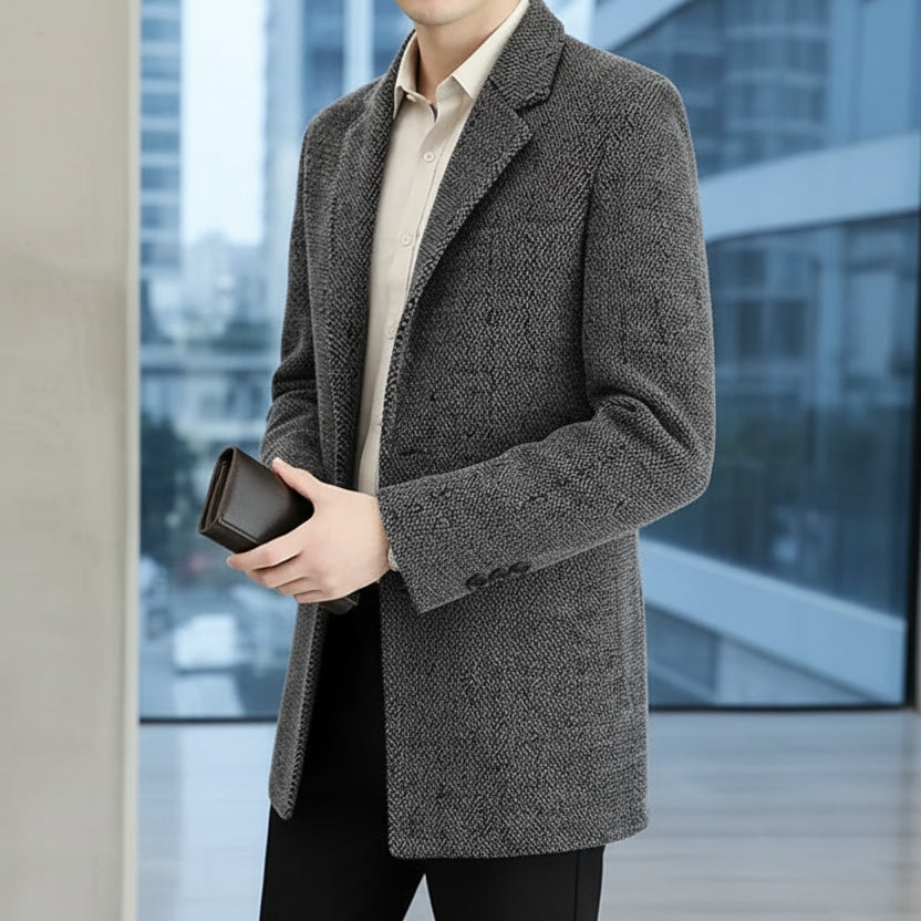 Person wearing a gray textured coat holding a phone in an indoor setting