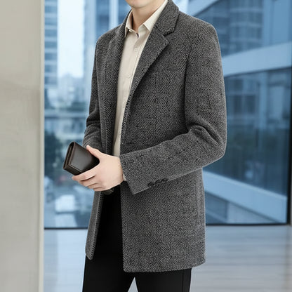 Person wearing a gray textured coat holding a phone in an indoor setting
