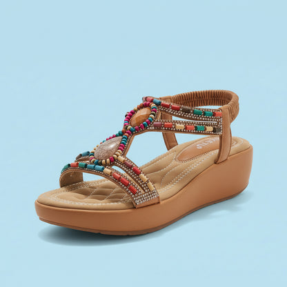 Tan wedge sandal with colorful beading on a white background