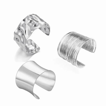 Three silver cuff bracelets on a white background