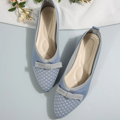 Pair of blue patterned shoes with a bow on a light gray background