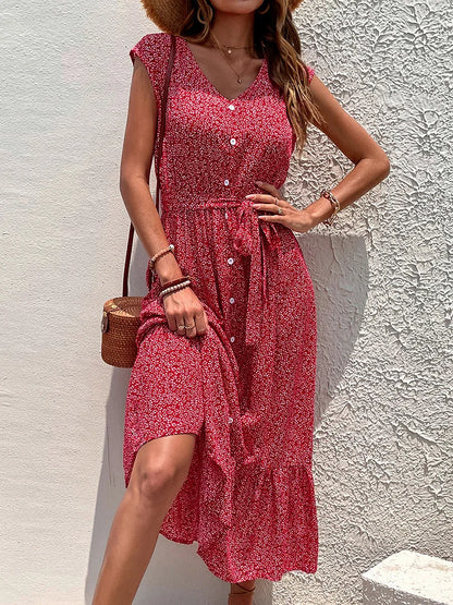 Woman wearing a red floral dress against a white wall
