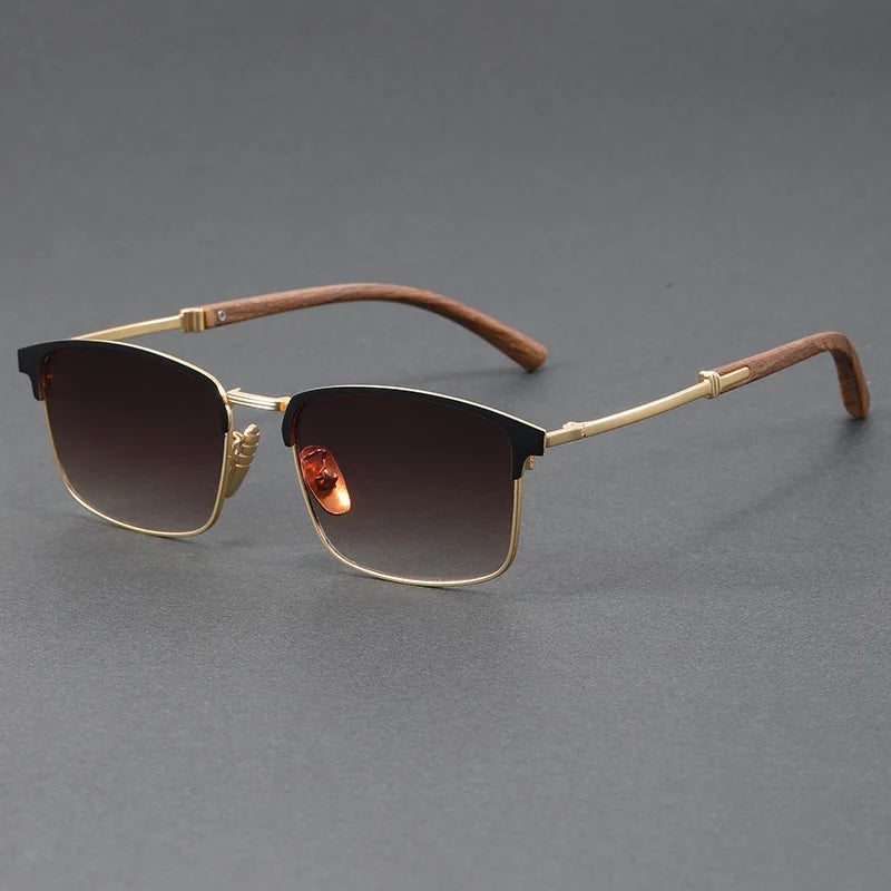 Sunglasses with gold frame and brown gradient lenses on a gray background