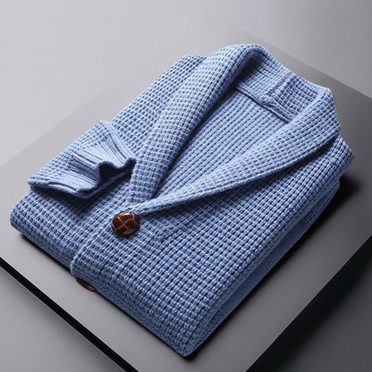 Folded blue robe with a brown button on a gray surface, with 'The Style of Boy City' branding.
