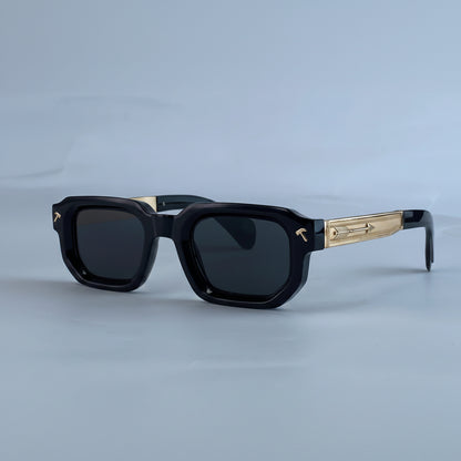 Black sunglasses with gold accents on a light blue background, featuring the brand 'KIM7KIM'.