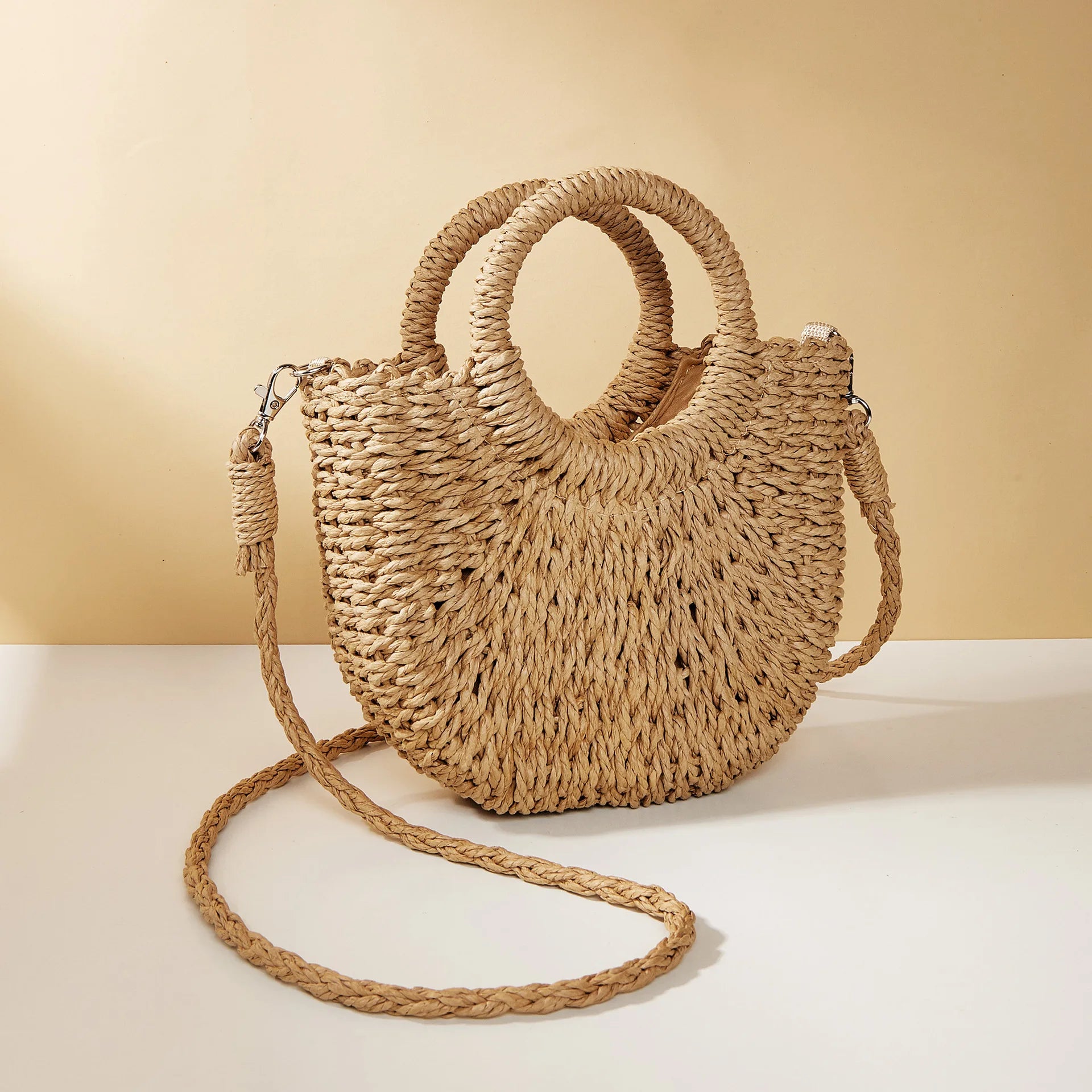 Woven straw handbag with a strap on a beige background