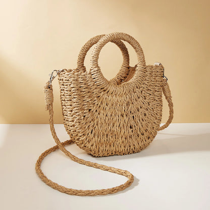 Woven straw handbag with a strap on a beige background