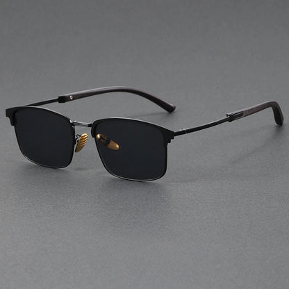 Sunglasses with black lenses and gold accents on a gray background