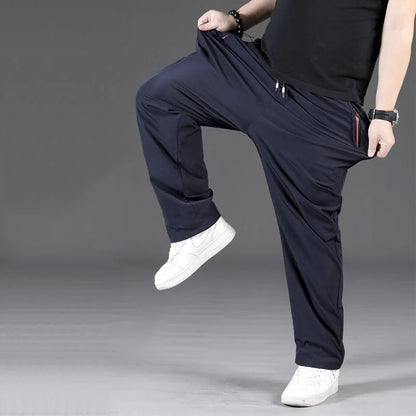 Person wearing navy blue pants and white shoes on a gray background