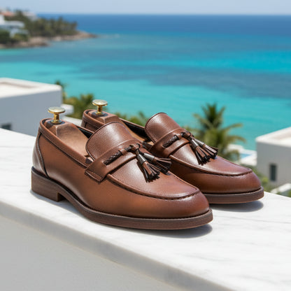 Brown leather loafers with tassels on a grid background