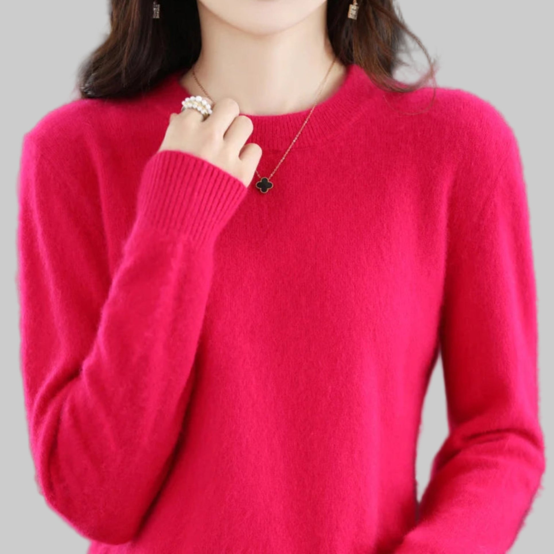 Person wearing a bright pink sweater with a blurred background