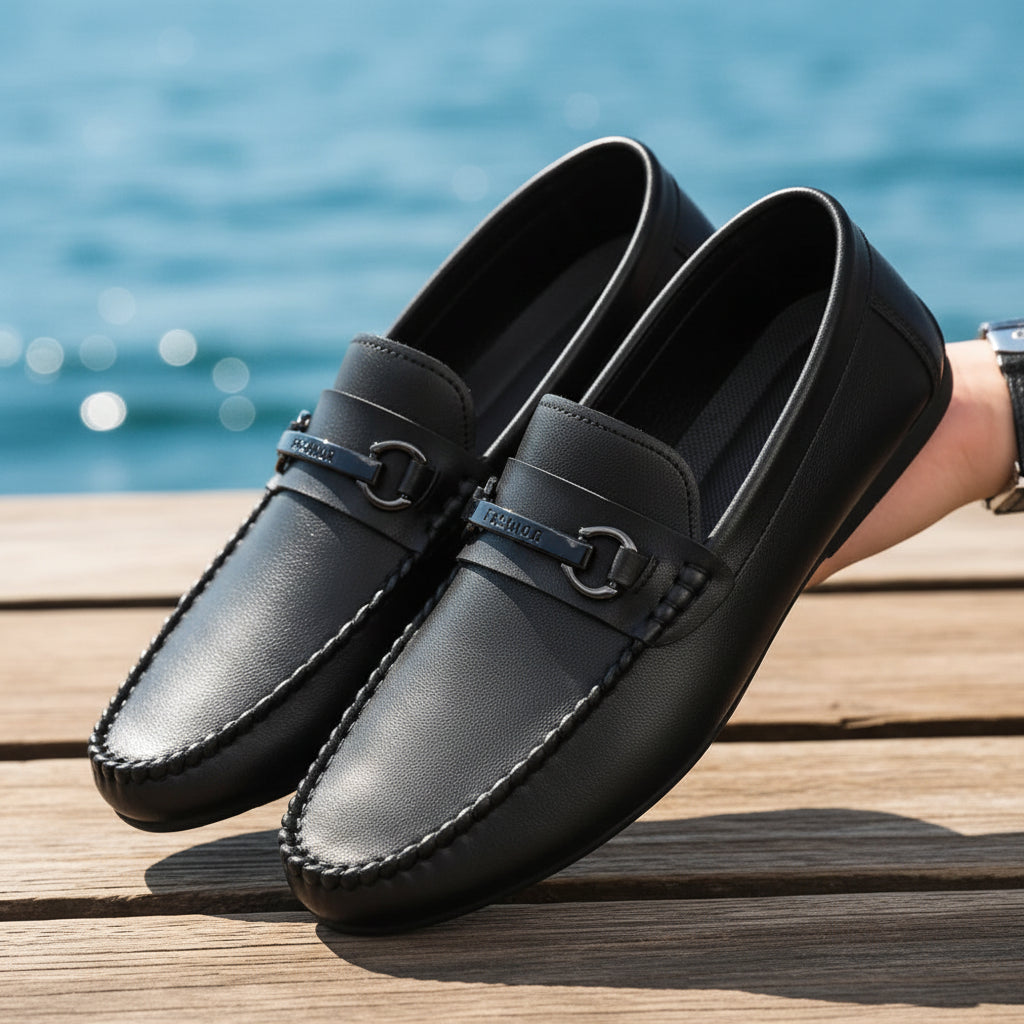 Black leather loafers held by a person with a blurred background