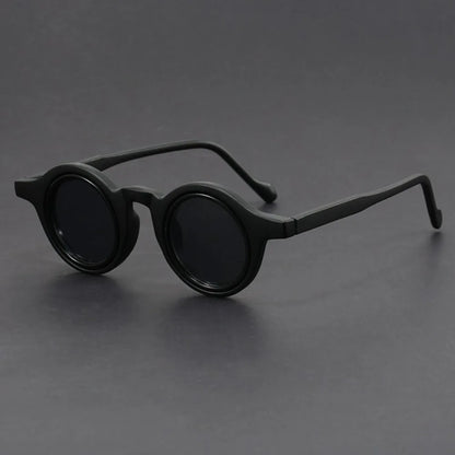 Black round sunglasses on a gray background