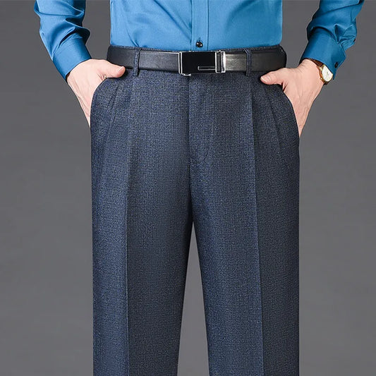 Person wearing a blue shirt and dark gray pants on a gray background
