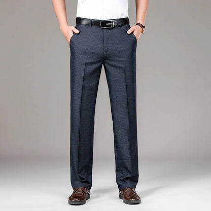 Person wearing dark gray pants with a white shirt and brown shoes on a gray background
