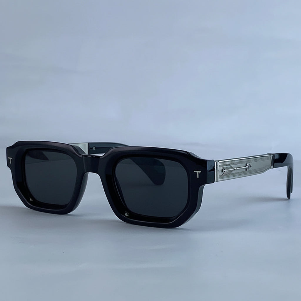 Black sunglasses with a gray frame on a light blue background, featuring the brand 'KIM7KIM'.