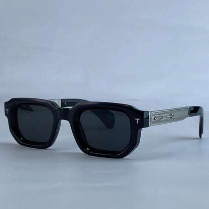 Black sunglasses with a gray frame on a light blue background, featuring the brand 'KIM7KIM'.